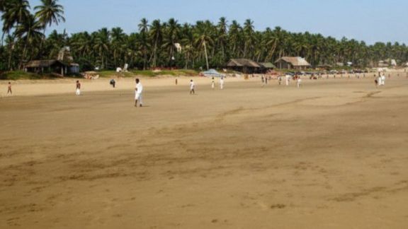 The video features calm waves washing over wide stretches of golden sand
