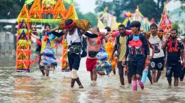 police: Devotees carry Ganga water in decorated kanwars as they walk through waterlogged streets amid rain during the ongoing Kanwar Yatra in the holy month of Sawan, in Haridwar