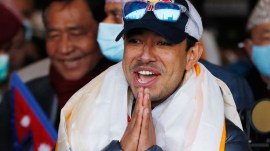 Nirmal Purja, one of the team member of the all-Nepalese mountaineering team that became the first to scale Mount K2 in winter, gestures as the team arrives at Tribhuwan International airport in Kathmandu, January 26, 2021. (AP File)