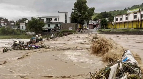 Floodwaters flow over a road after flash floods caused by incessant overnight rainfall, in Mendhar, Poonch district, Jammu and Kashmir, Sunday, July 19, 2026. (PTI Photo)