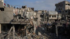 Palestinian residents save their belongings from destroyed buildings following an Israeli airstrike last night, at al-Bureij refugee camp, central Gaza Strip (AP Photo)