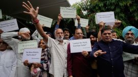 Members of SOS International, an organization representing people who migrated from Pakistan-occupied Kashmir (PoK) in 1947, hold placards during a protest against the alleged atrocities committed by Pakistan, in Jammu