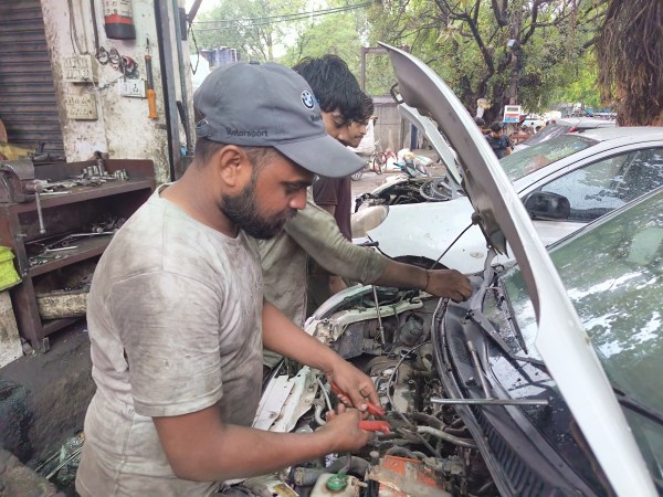  Rupesh Kumar fixing a car at the Mayapuri scrap yard. (Express Photo by Devansh Mittal)