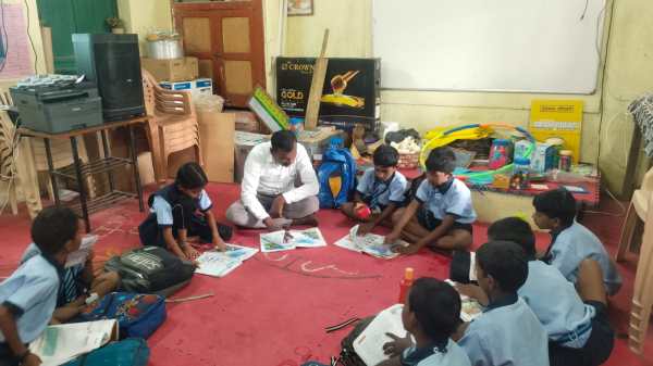Yavatmal village school, teacher student sit on floor