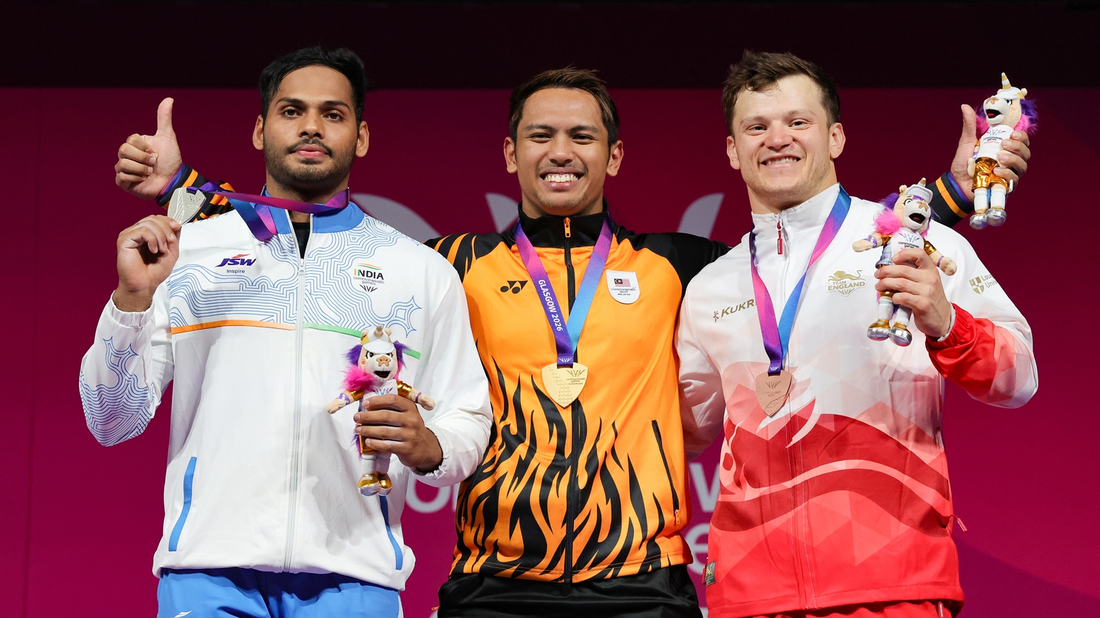 Erry Hidayat Muhammad of Malaysia with his gold medal alongside Valluri Ajaya Babu of India with his silver medal, left, and Chris Murray of England with his bronze medal, right, after the Men's 79kg weightlifting competition during the Commonwealth Games in Glasgow, Scotland, Monday, July 27, 2026. (Steve Welsh/PA via AP)
