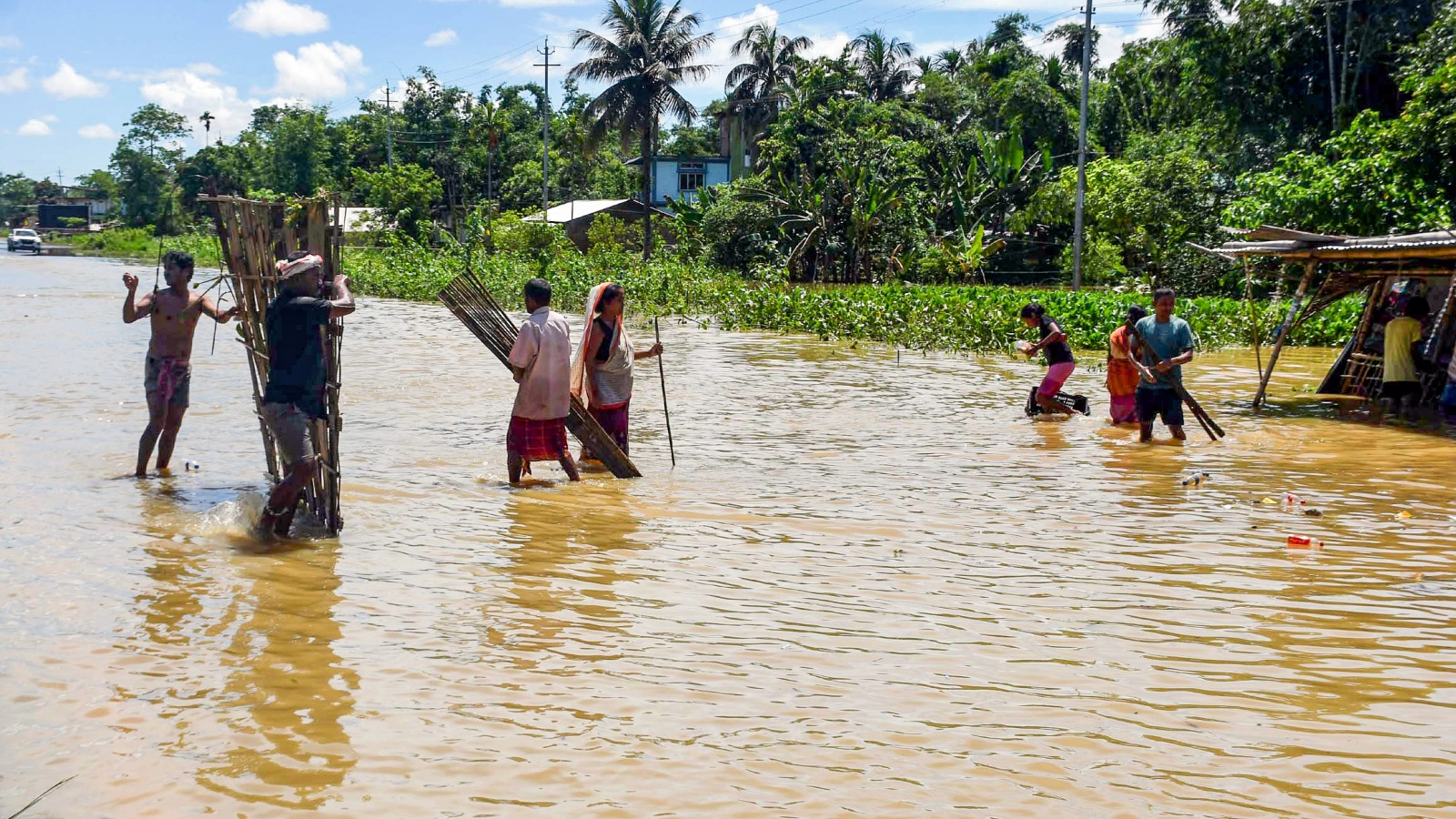Villagers wade through flood water at Teok