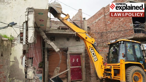 A bulldozer demolishes a house built on government land.