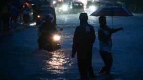 Pedestrians, and vehicles navigate through waterlogged streets in Vasai as heavy rain lashes Palghar district. (Express Photo: Sankhadeep Banerjee)