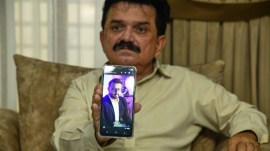 Ghulam Nabi Bahrani, father-in-law of missing cargo plane crew First Officer Faisal Jatoi, showed his picture on a mobile phone in Karachi, Pakistan, Wednesday. (AP Photo)