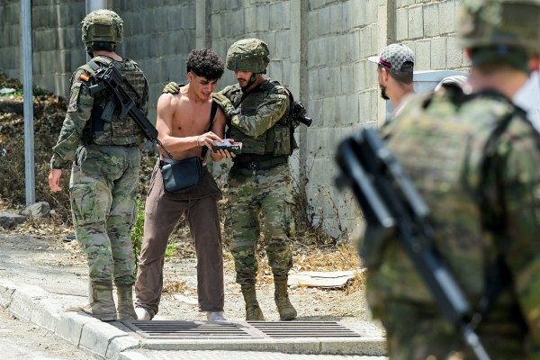 Spanish soldiers question a migrant, following mass crossings of migrants on foot and by sea from Morocco into Spanish territory, in Ceuta, August 1, 2026. (REUTERS)