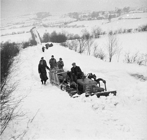 A bulldozer towing a sledge delivers bread to the snowbound village in Britain, 1947 (Wikipedia)