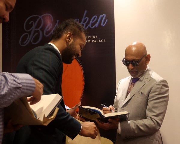 Andrew Ramroop signing the book Bespokenv.