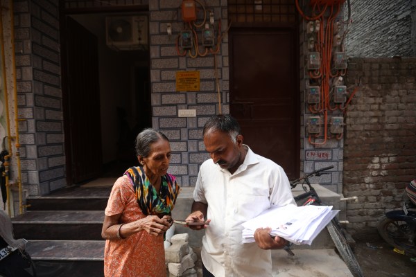 Geeta, a resident of Sangam Vihar, with assistant BLO Mukesh Chandra Meena. (Express Photo by Gajendra Yadav)