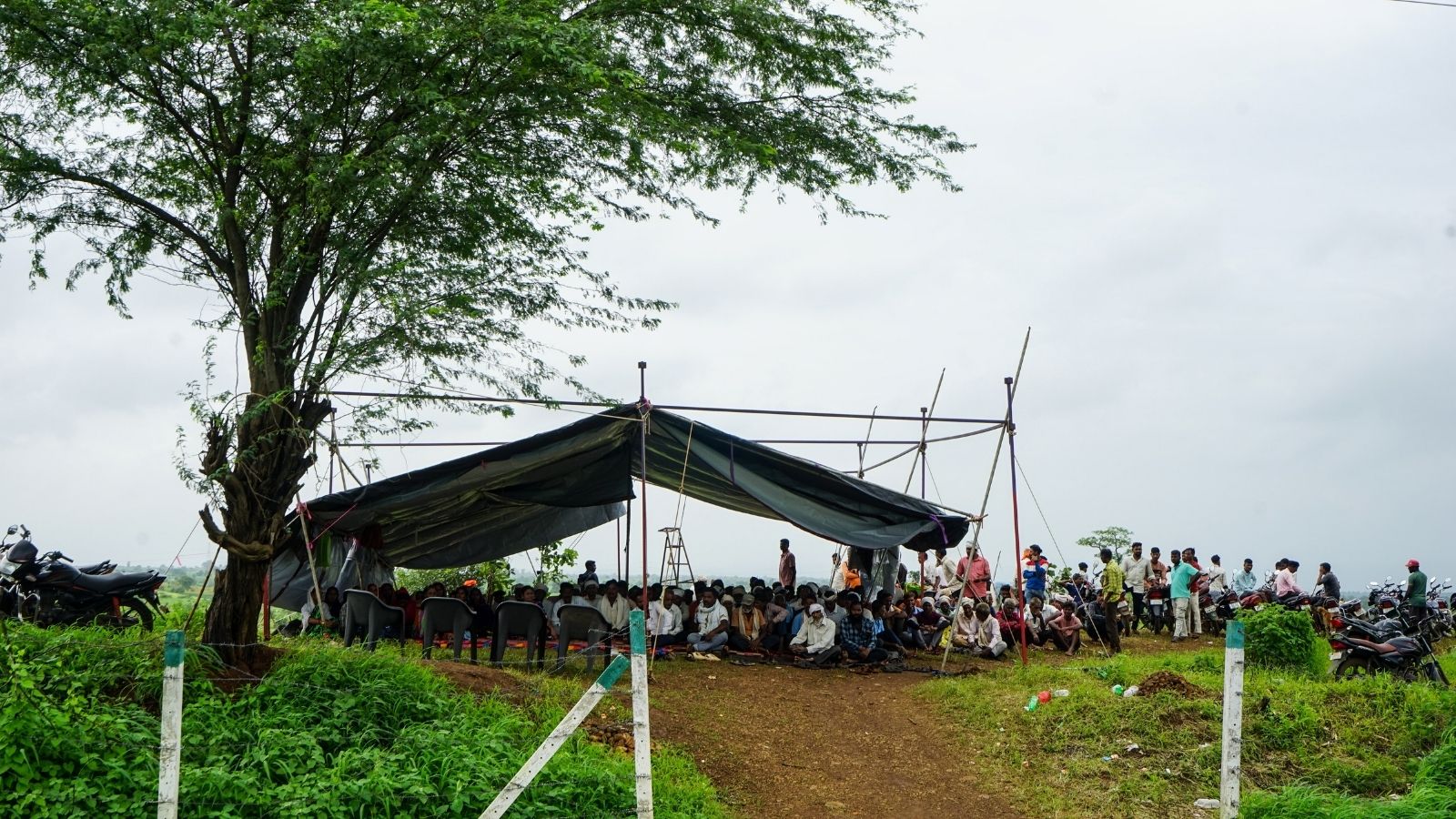 Tribal villagers sit under a tarpaulin tent during a relay fast over cultivation rights to disputed forest land in Gujarat. (Express Photo)