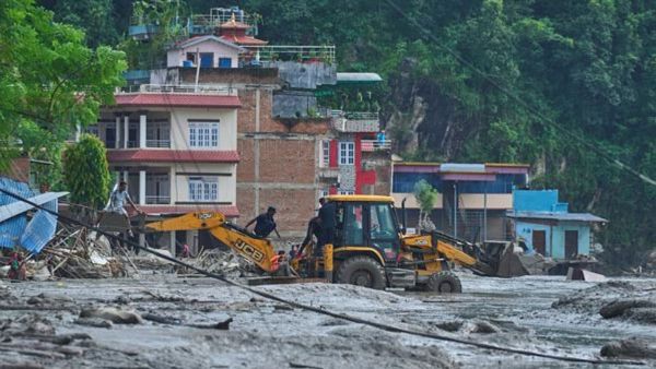 Rescuers use earthmovers to reach submerged houses after flash flooding along the Trishuli River in Nepal's Nuwakot district (AP Photo)