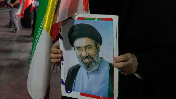 An Iranian pro-government demonstrator holds a poster of the Supreme Leader Ayatollah Mojtaba Khamenei in a gathering at a square in Tehran, Iran (AP Photo)