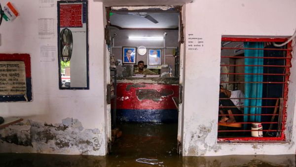 A police officer sits inside a waterlogged George Town police station, Wednesday (PTI Photo)