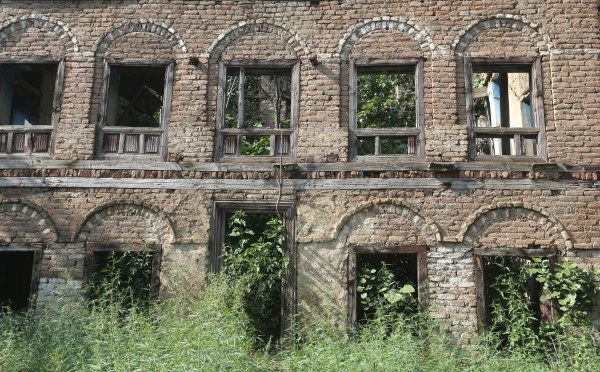 in the heart of the village, four rundown brick-and-stone houses belonging to the Pandits remain standing, frozen in time. Time and weather have torn away most of the structures, and dense green vegetation grows out of the windows and archways.