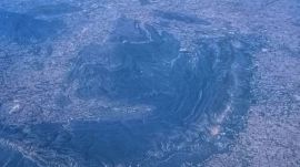 An aerial view of some hills in the Aravallis range surrounded by dense settlements in Haryana. (Tashi Tobgyal)