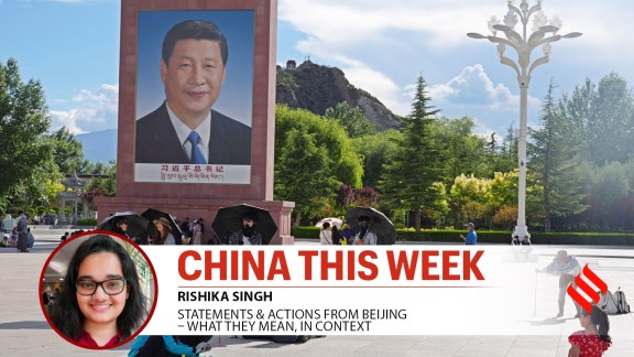 Tourists rest near a portrait of Chinese President Xi Jinping at a public square at the base of the Potala Palace in Tibet.