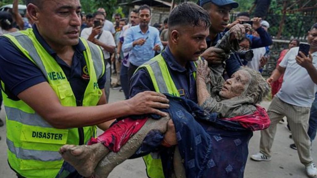 Rescuers carry a victim of flash flooding to safety along the Trishuli River in Nepal's Nuwakot district, Wednesday. (AP Photo)