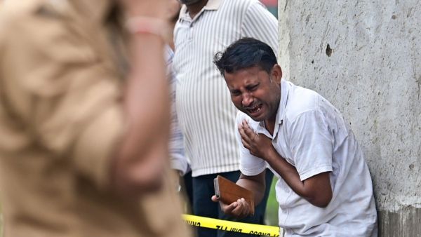 Family members mourn after a massive explosion at a firecracker factory, in Kaushambi, Uttar Pradesh, Monday. (PTI Photo)