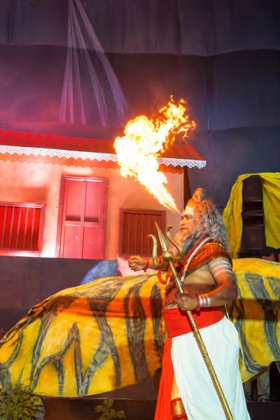A sadhu holding a trishul: A dramatic fire-breathing act brings the jivant dekhava to life at navnath Tarun Mandal Trust, LBS Road, Sadashiv Peth, captivating Ganeshotsav visitors with its striking visuals and theatrical flair. (Express Photo)