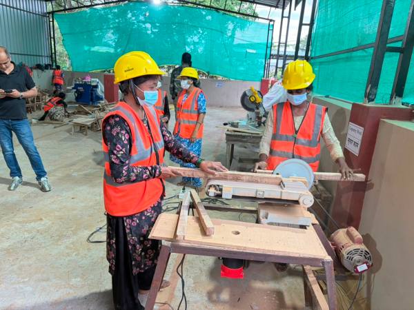 Kavita (L) working on the pneumatic sander