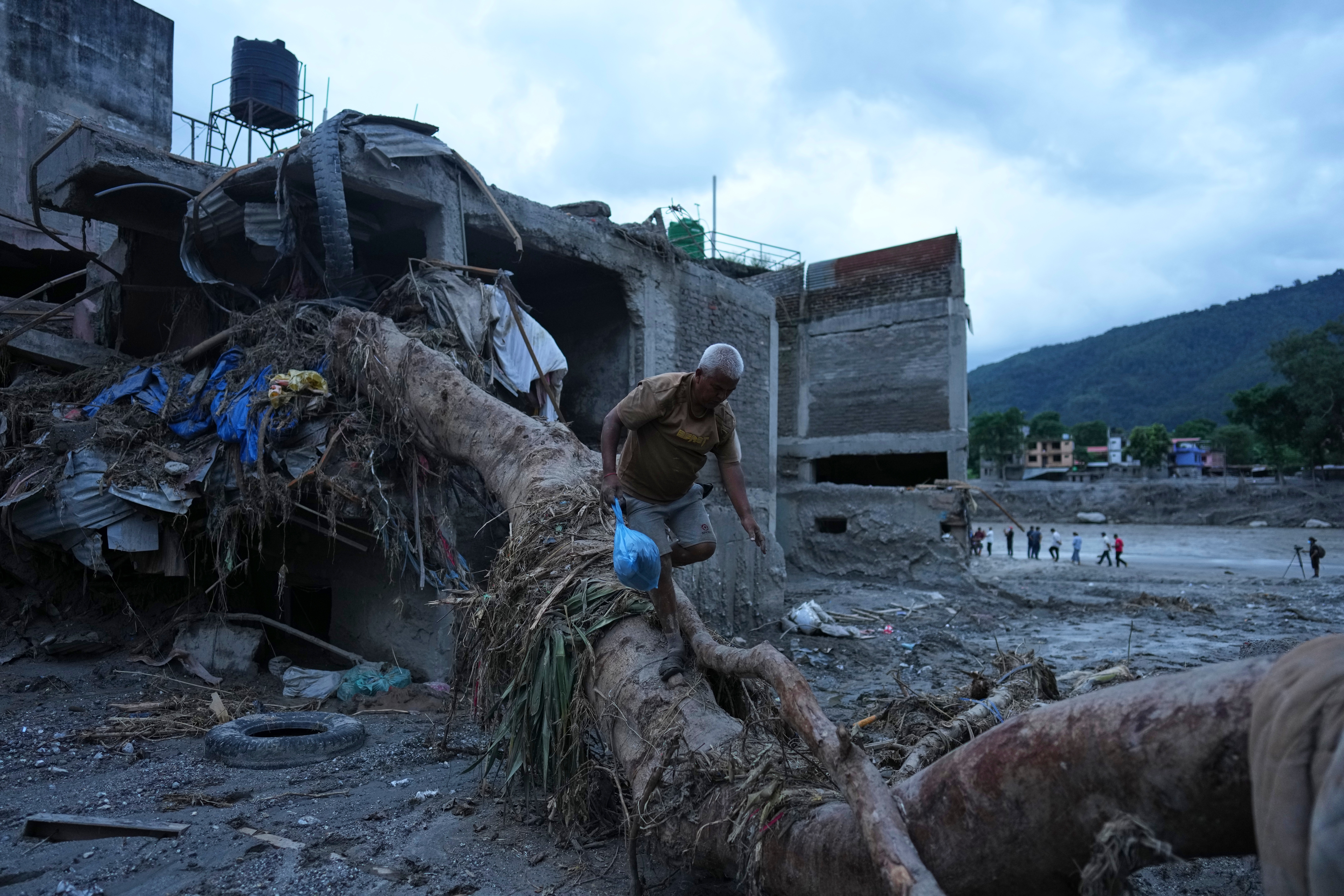 A resident salvages belongings from his damaged home after flash flooding in the Devighat area of Nuwakot district in Nepal, Monday, Aug. 31, 2026. (AP Photo)