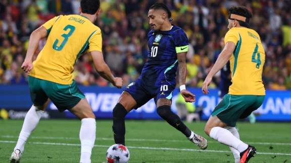 Brazil's Raphinha, center, has a shot past Australia's Alessandro Circati, left, during their international friendly soccer match in Brisbane, Australia, on Tuesday, Sept. 29, 2026. (AP Photo/Tertius Pickard)