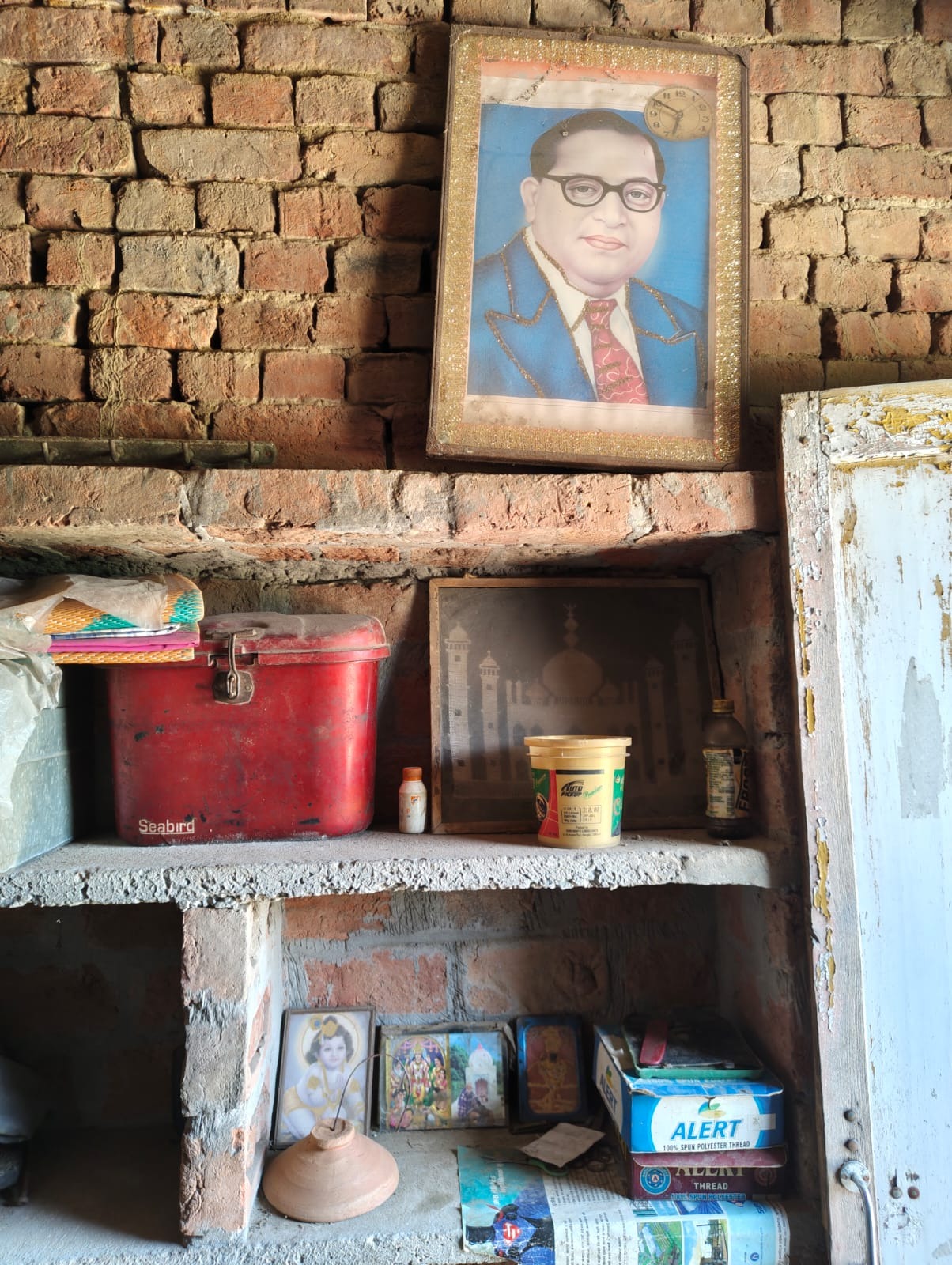 A prayer niche in a Jatav household in Akbarpur, where Ambedkar and Neem Karauli Baba now share a wall. (Express Photo by Deepak Tenguria)