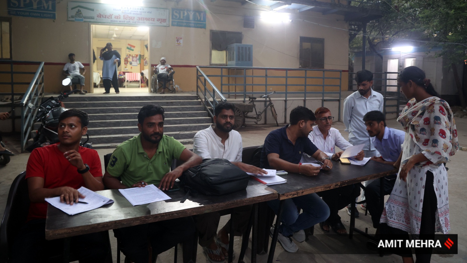 Five Booth Level Officers (BLOs) — teachers and bank officials — sat at two tables to help residents.