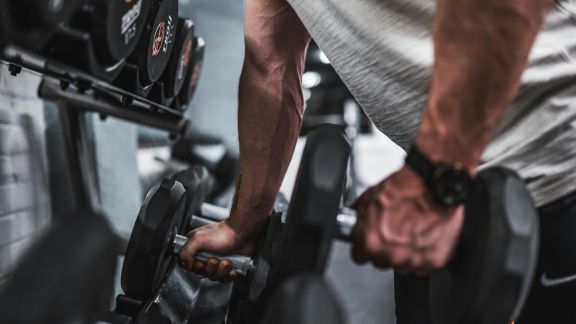 Person lifting weights during a progressive strength training workout