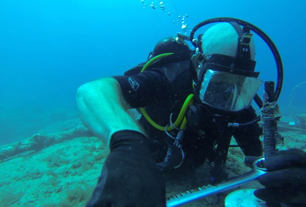 A worker repairs an underwater cable. (Wikimedia Commons)