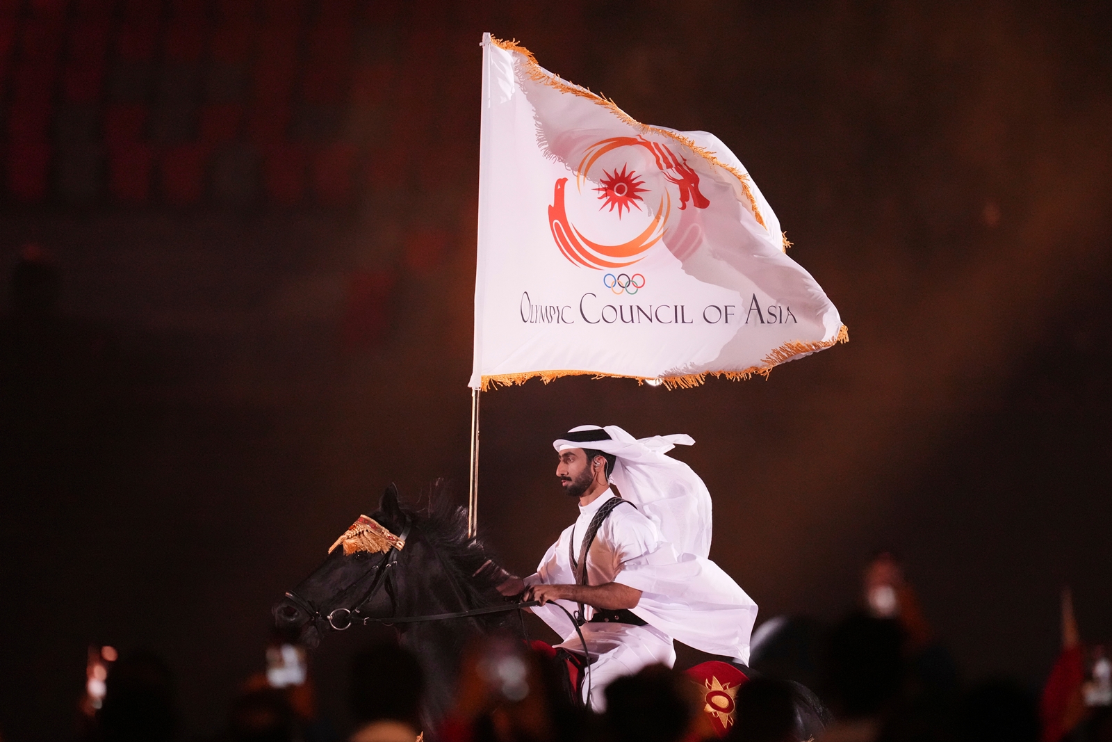 Qatar equestrian athlete Jassim Al Kuwari rides with the Olympic Council of Asia flag during the closing ceremony for the Asian Games in Nagoya