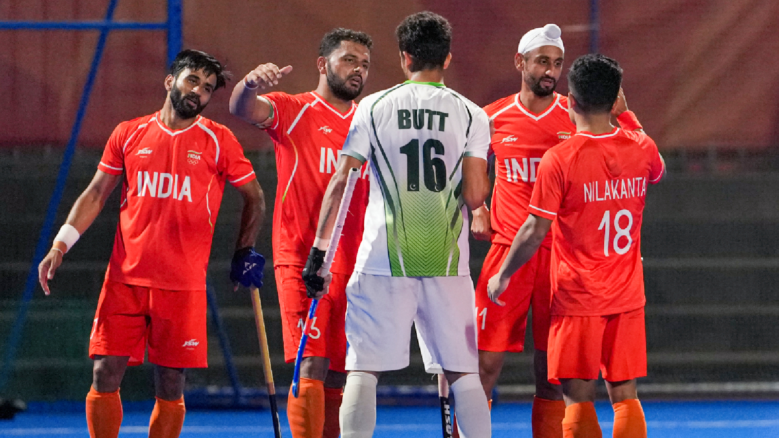 India's captain Harmanpreet Singh, 13, Mandeep Singh, 11, and Manpreet Singh, 7, being congratulated by Pakistan's Ammad Butt, 16, after winning the men's semifinal hockey match between India and Pakistan