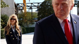 New White House Press Secretary Katie Zacharia stands behind US President Donald Trump as he departs the White House in Washington, DC, US, October 13, 2026. (REUTERS)