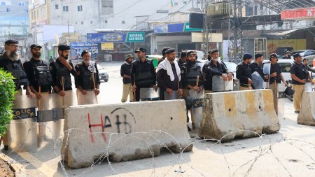 Members of the police guard a road leading to the Red Zone, in Peshawar, Khyber Pakhtunkhwa province, Pakistan