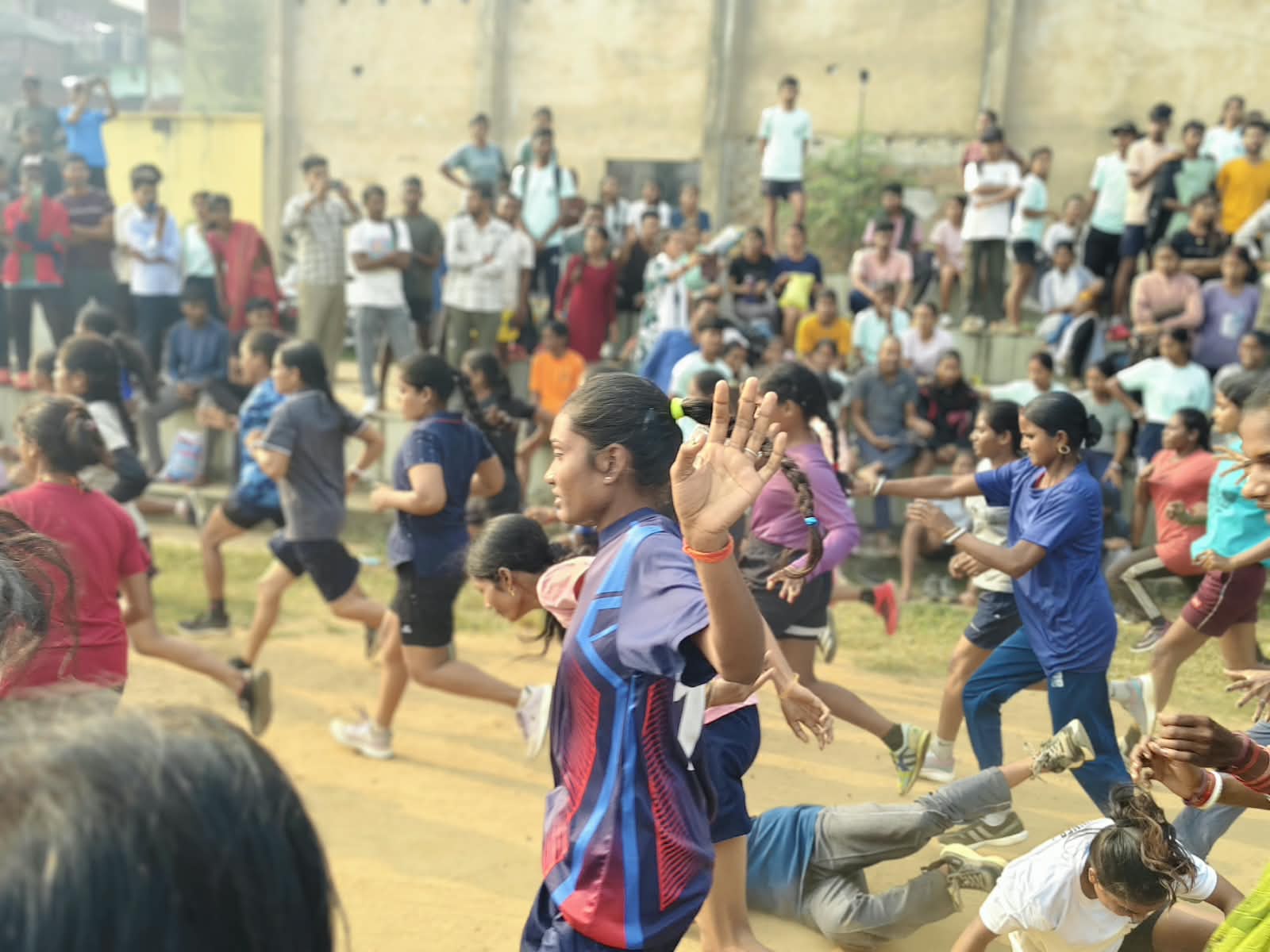 Women trip, as the dust raised by their run blinds them