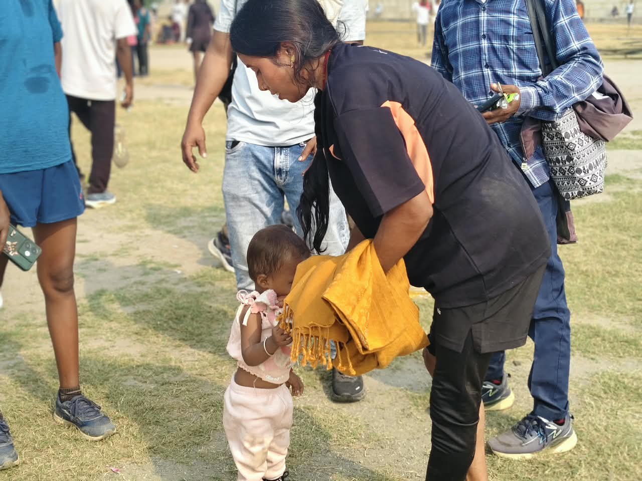 Yashoda Devi tends to her daughter Myra at the stadium
