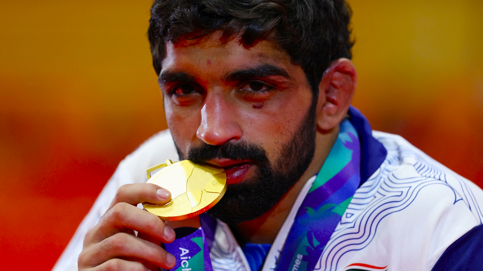 India's Aman Sehrawat celebrates with the gold medal after winning the men's freestyle 57kg gold medal bout.