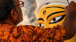An artist paints the eyes of the Durga idol.