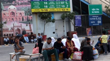 Passengers waiting outside New Delhi railway station on Friday (Express photo by Amit Mehra)