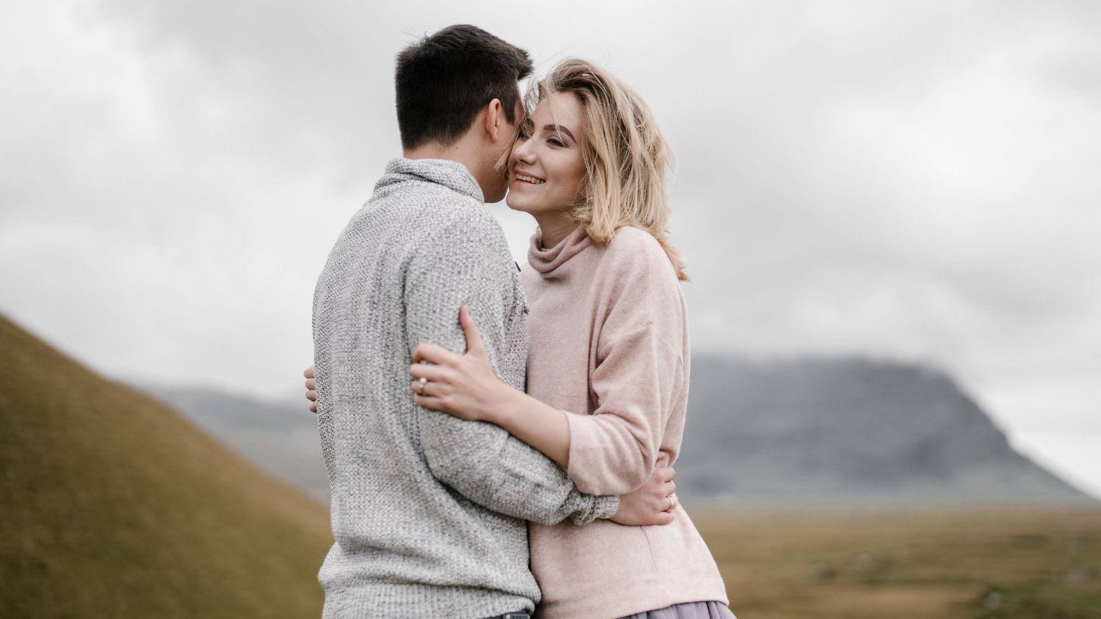 Couple sharing physical intimacy while navigating emotional distance in their relationship.