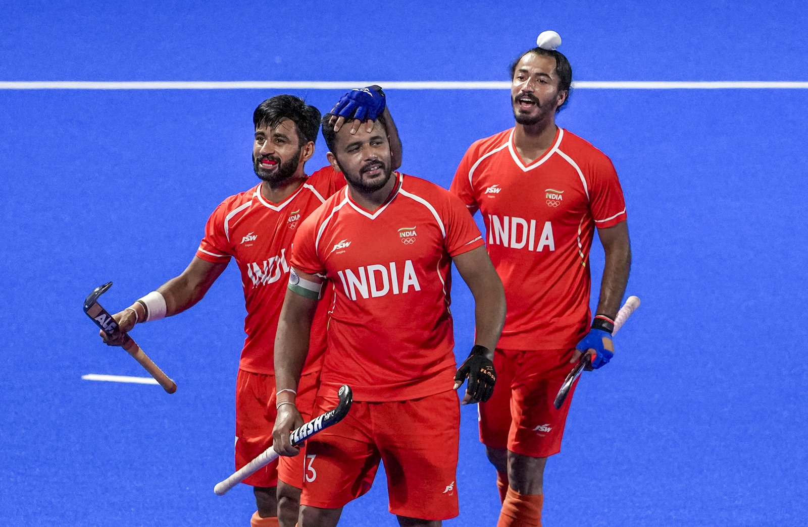 India's captain Harmanpreet Singh, centre, celebrates with Manpreet Singh, left, and Dilpreet Singh after scoring a goal during the men's final hockey match between India and Malaysia, at the ongoing 20th Asian Games, in Kakamigahara, Japan, Saturday, Oct. 3, 2026. (PTI10_03_2026_000437B) *** Local Caption ***