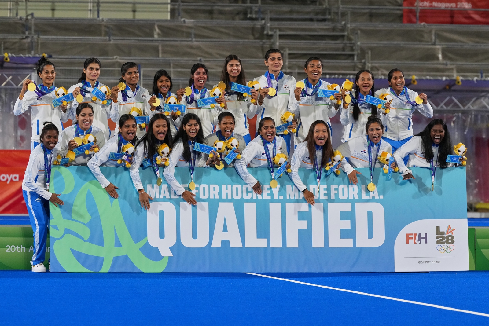 Gold medalists India celebrate on the podium holding a board stating their qualification to LA olympics, during the medal ceremony after the women's hockey finals at the Asian Games in Gifu, Japan, Friday, Oct. 2, 2026. (AP Photo/Mark Baker)