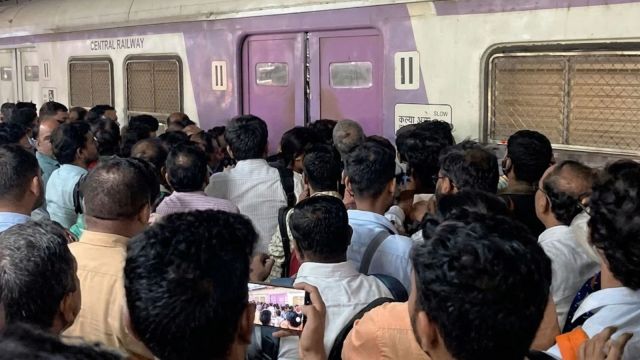 A screengrab of the incident at Thane railway station when railway staff allegedly kept the doors of an employee special local train shut, sparking chaos. (Image enhanced using AI)